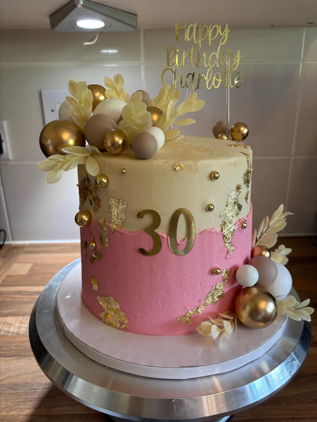 Pink and cream thirtieth birthday cake with gold leaf, gold spheres and floral decorations